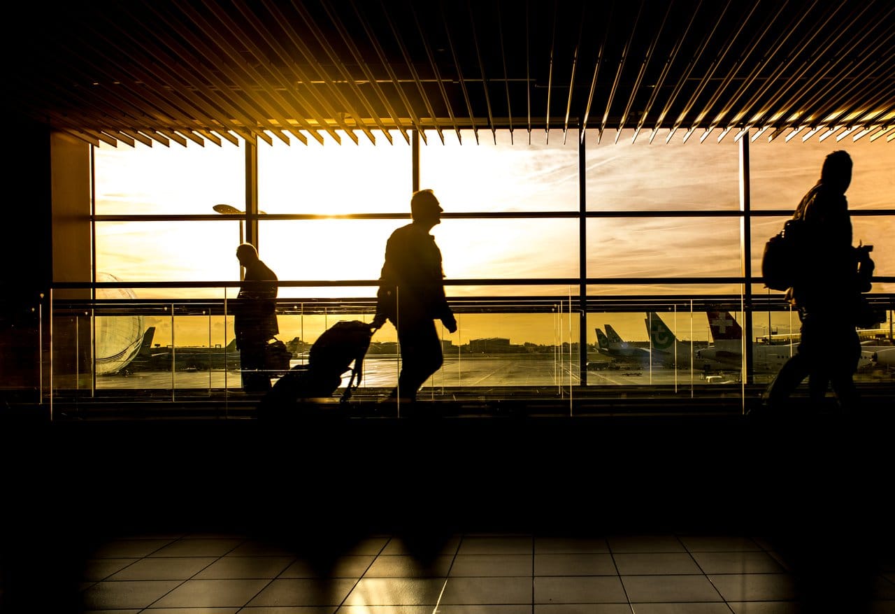 Silhouette of person walking through an airport with luggage, representing immigrants coming to Canada