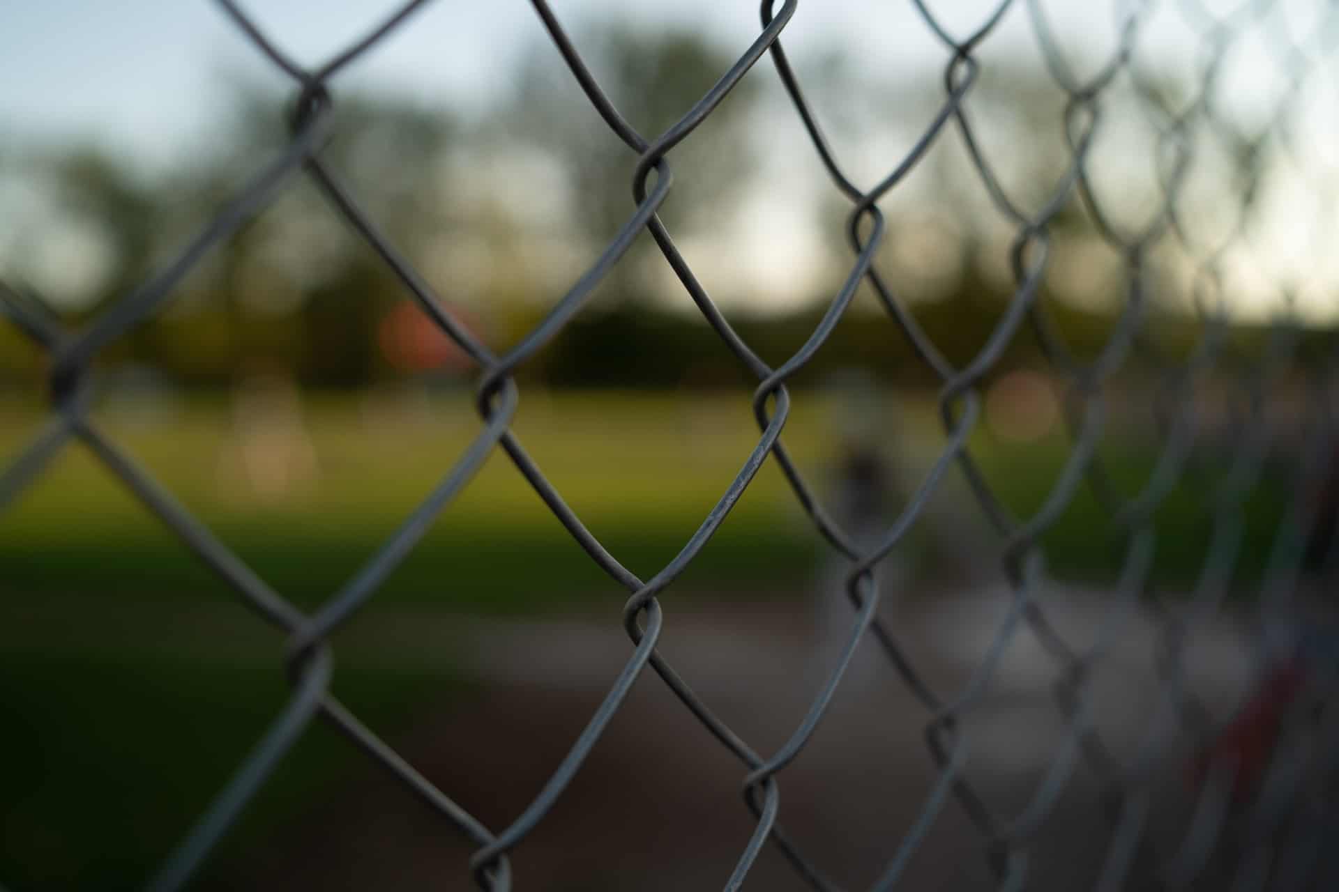 A chainlink fence representing the Canada/US border