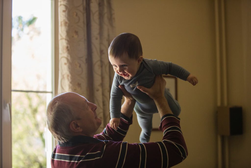 An elderly man holding his grandchild represent new compassionate exemptions to the border closure