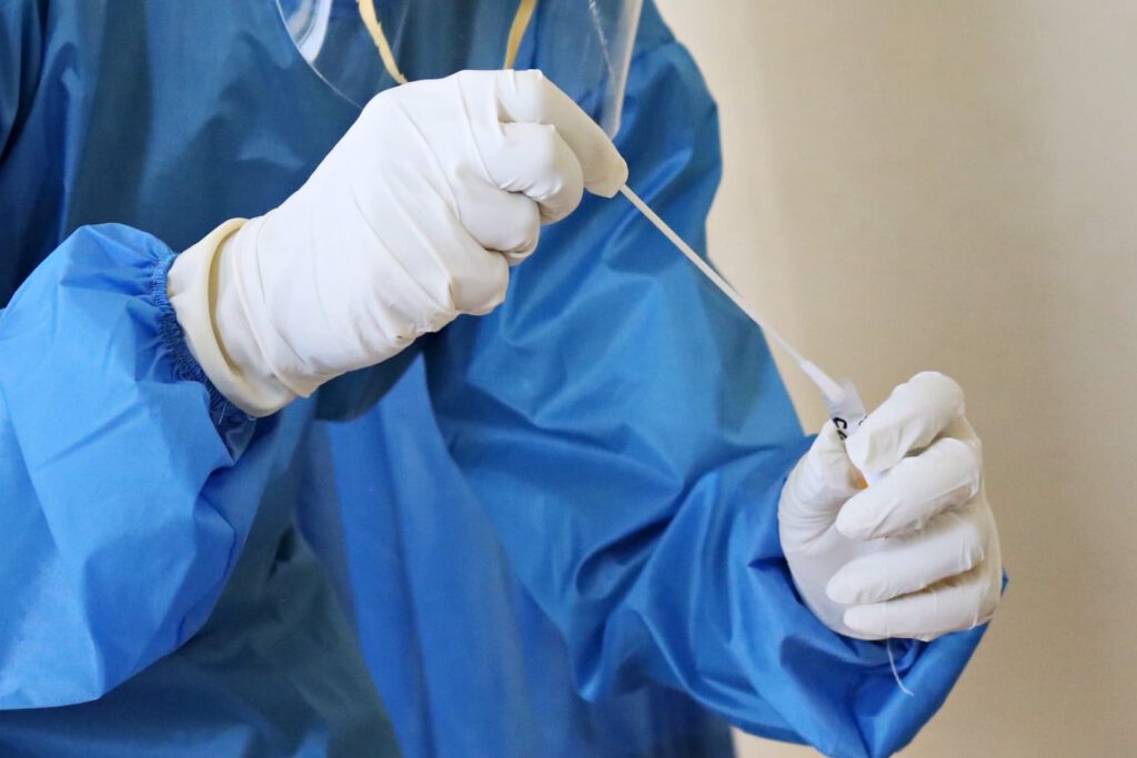 A person performing a cOVID test representing the pilot program to reduce quarantine in Alberta
