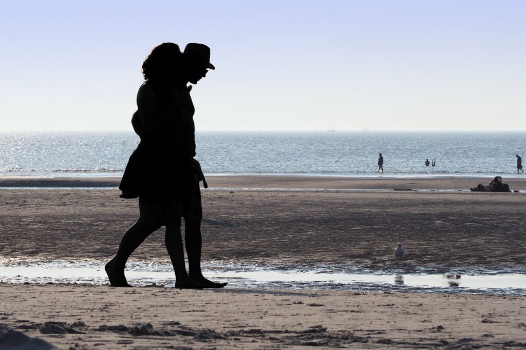 Couple walking on a beach representing snowbirds looking to spend winter in the U.S.