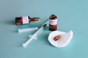Vials labelled as COVID-19 vaccines along with a syringe representing travel after the vaccine