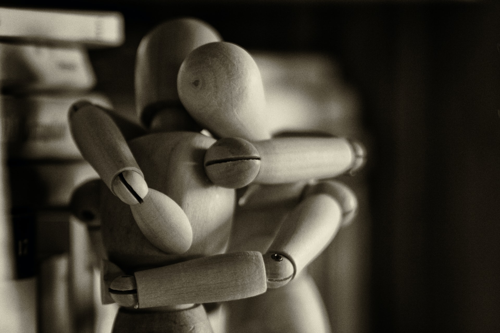Two wooden figures in an embrace representing spousal reunions after immigration Canada steps up efforts to process more applications