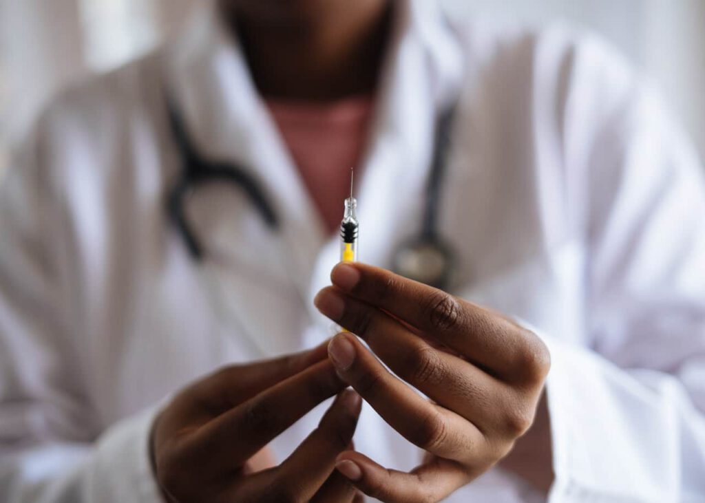 A medical professional with a syringe representing new streams for permanent residence for temporary workers in Canada