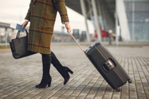 A woman walking with travel documents and a suitcase representing Canada implementing vaccine passports for international travel.