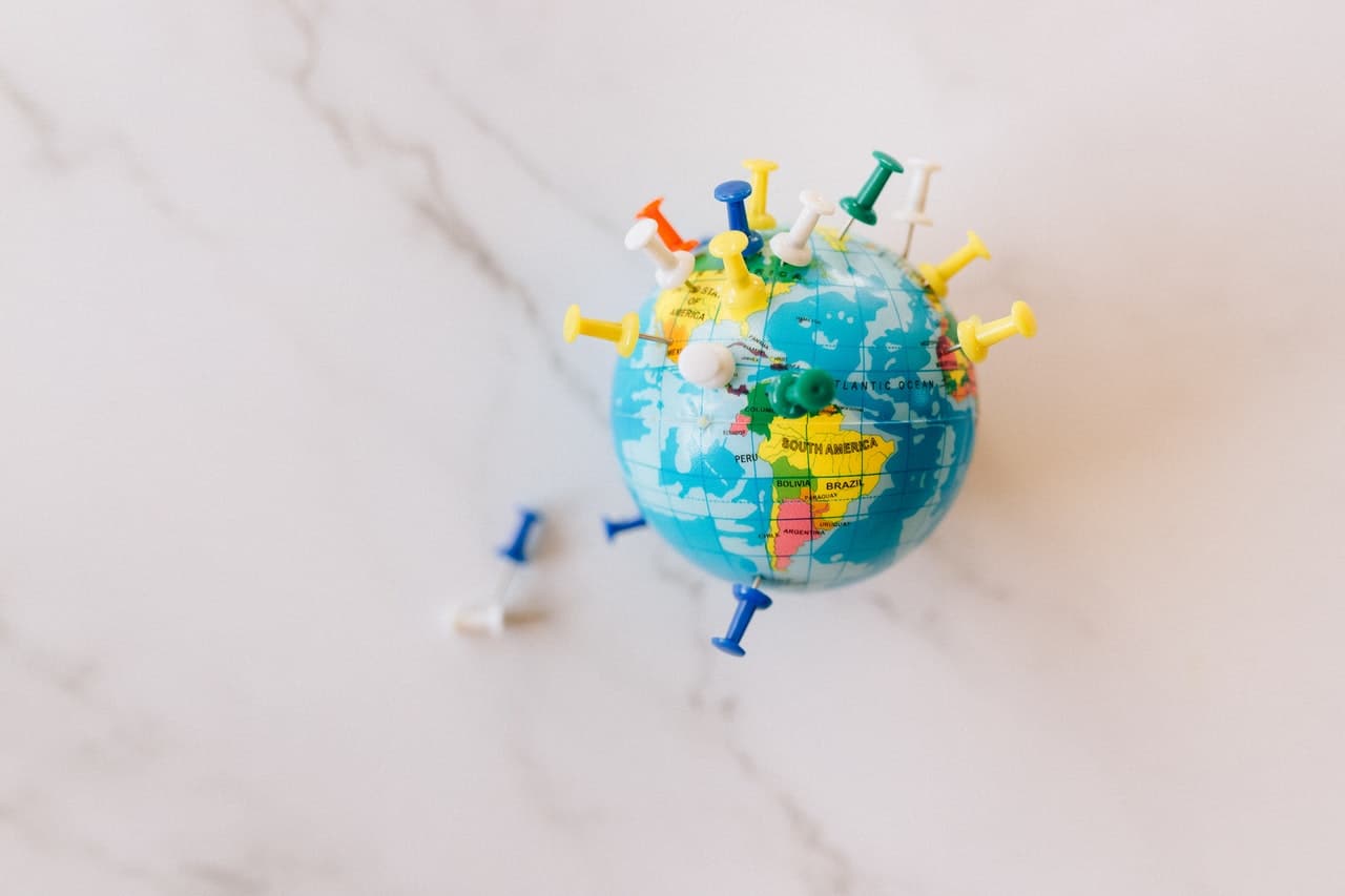 A globe with pins representing rules around travel for Canadians to various destinations around the world