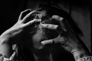 woman holding her head in hands