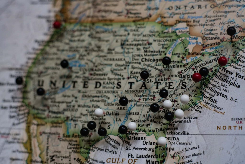A map of the United States of America with pins in it, representing business visas for Canadians doing business in the U.S.