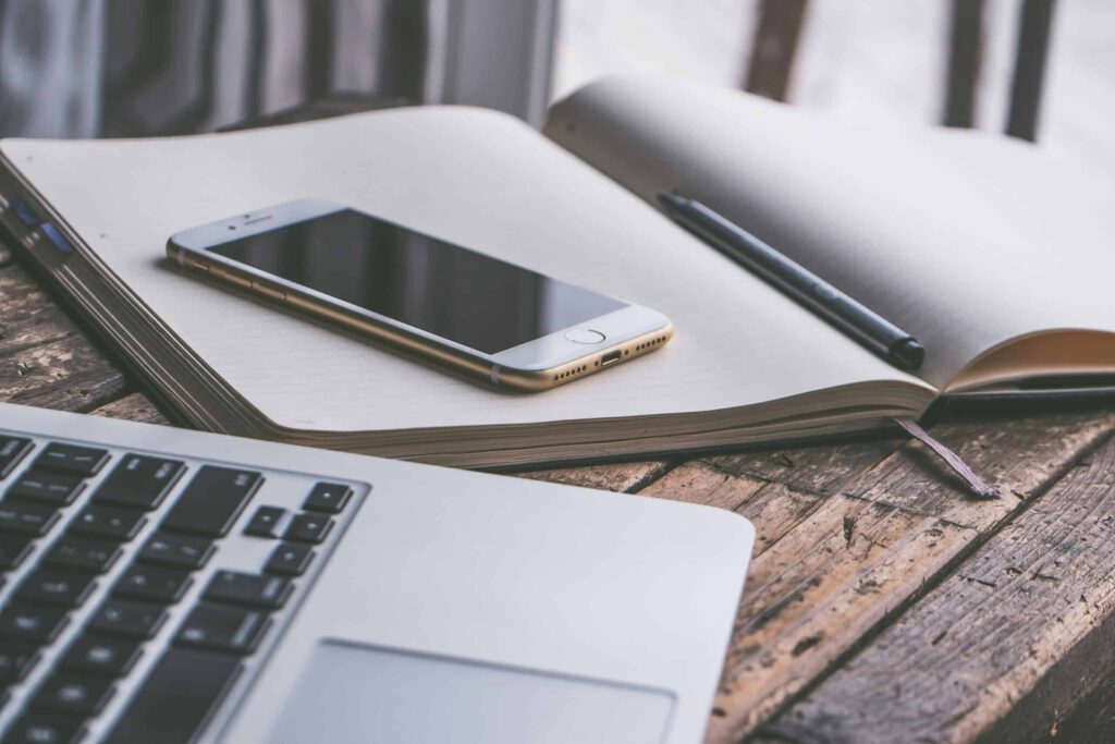 Laptop, notebook and phone representing Express Entry and the changes to the program