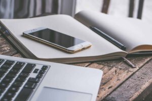 Laptop, notebook and phone representing Express Entry and the changes to the program