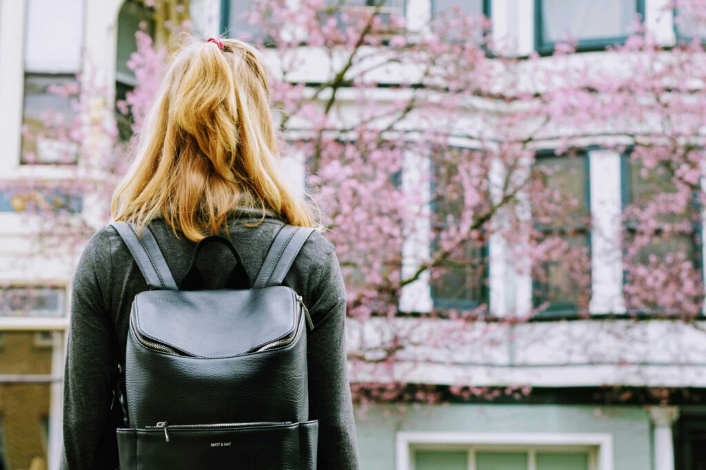 Person carrying backpack representing study permit allocations for 2024