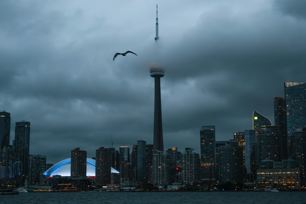 Cloudy evening Toronto skyline with the CN Tower partially obscured by clouds, representing Garson Immigration Law and its partners being named to the 2026 edition of The Best Lawyers in Canada