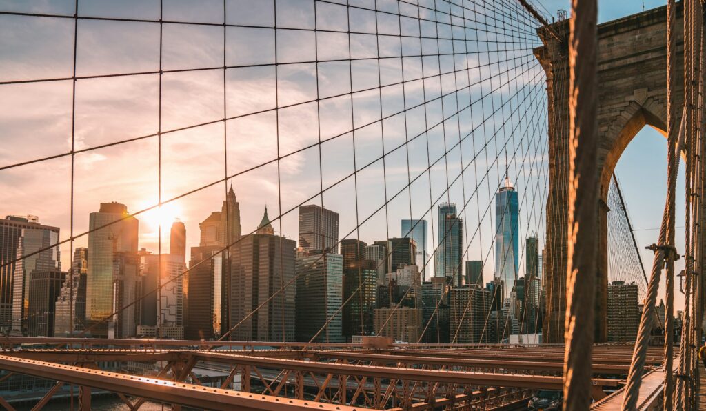 Manhattan skyline and Brooklyn Bridge at dusk, relevant to U.S. immigration news on the $100,000 H-1B fee and Gold Card visa.