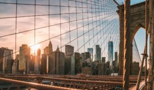 Manhattan skyline and Brooklyn Bridge at dusk, relevant to U.S. immigration news on the $100,000 H-1B fee and Gold Card visa.
