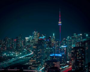 The Toronto skyline at night with The CN Tower and office and apartment buildings lit up against a midnight-blue sky, representing Best Law Firms Canada.