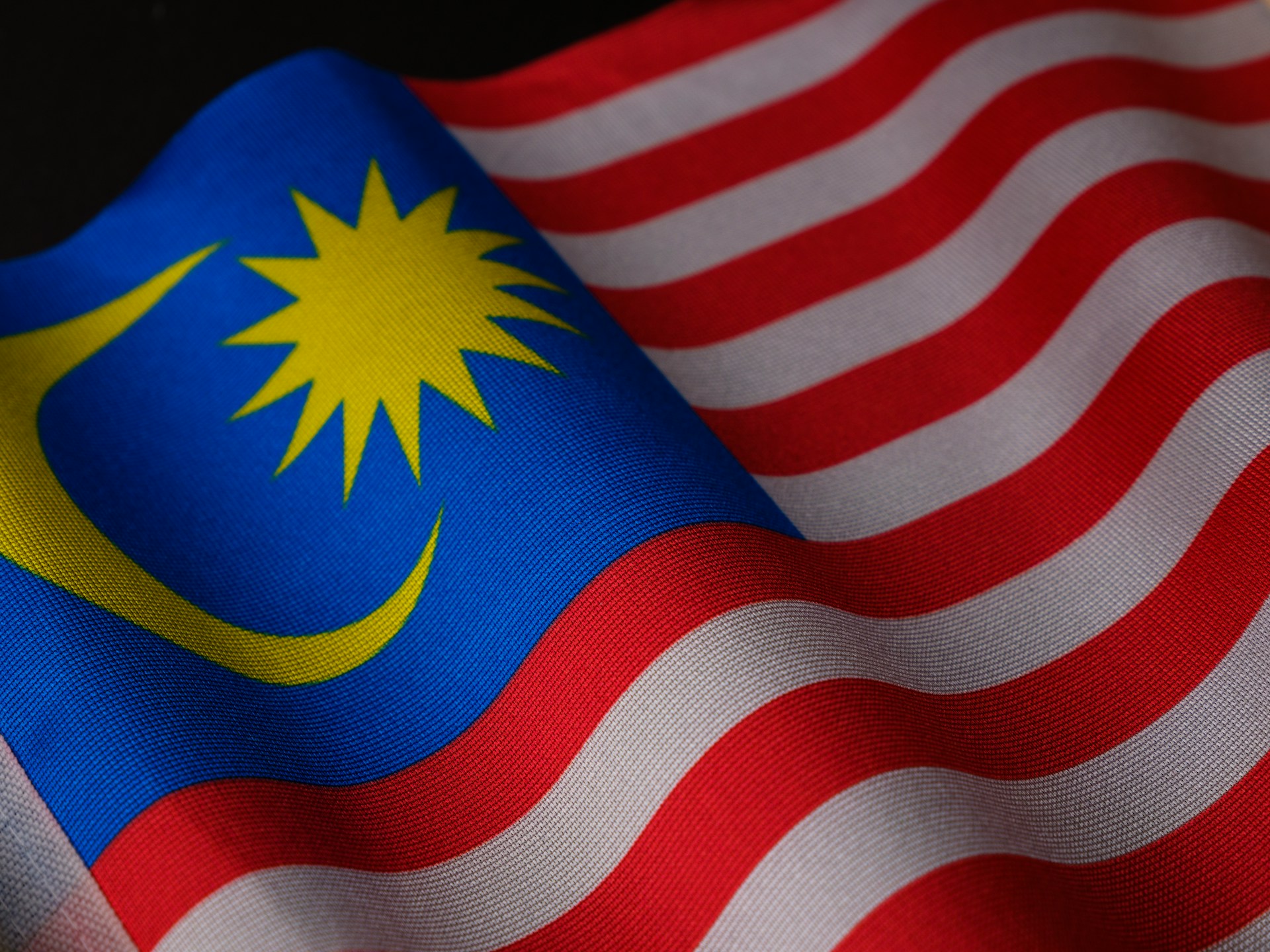 Close-up of the flag of Malaysia, representing the 2026 changes to visa travel rules when travelling from Malaysia and Indonesia to Canada