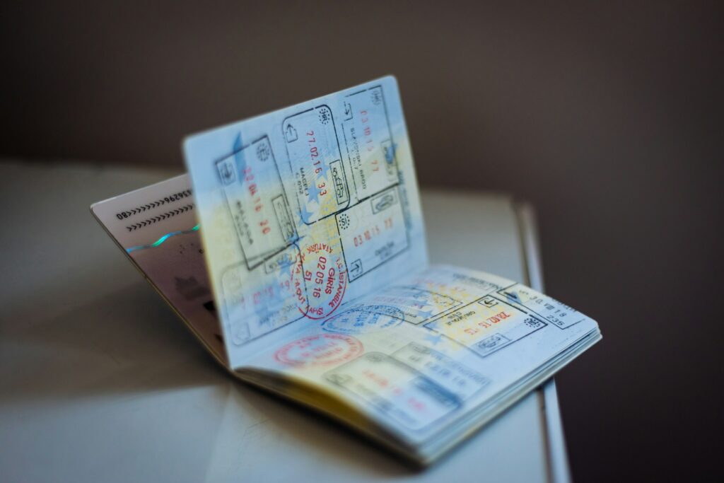 An open passport with multiple stamps on the pages set on the corner of a table, representing Canadian passport renewals.
